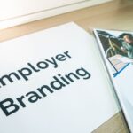 Een recruiter die LinkedIn gebruikt om talent aan te trekken via een laptop, met grafieken en statistieken op het scherm.